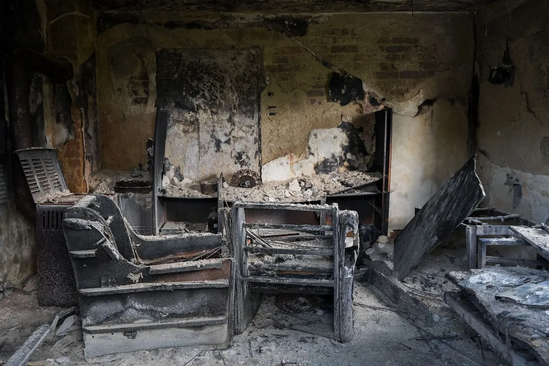 Interior room showing heavy char and smoke damage after a structure fire