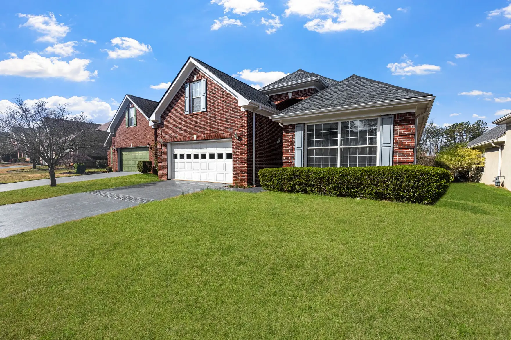 Brick single-family homes with shaded lawns in a suburban neighborhood
