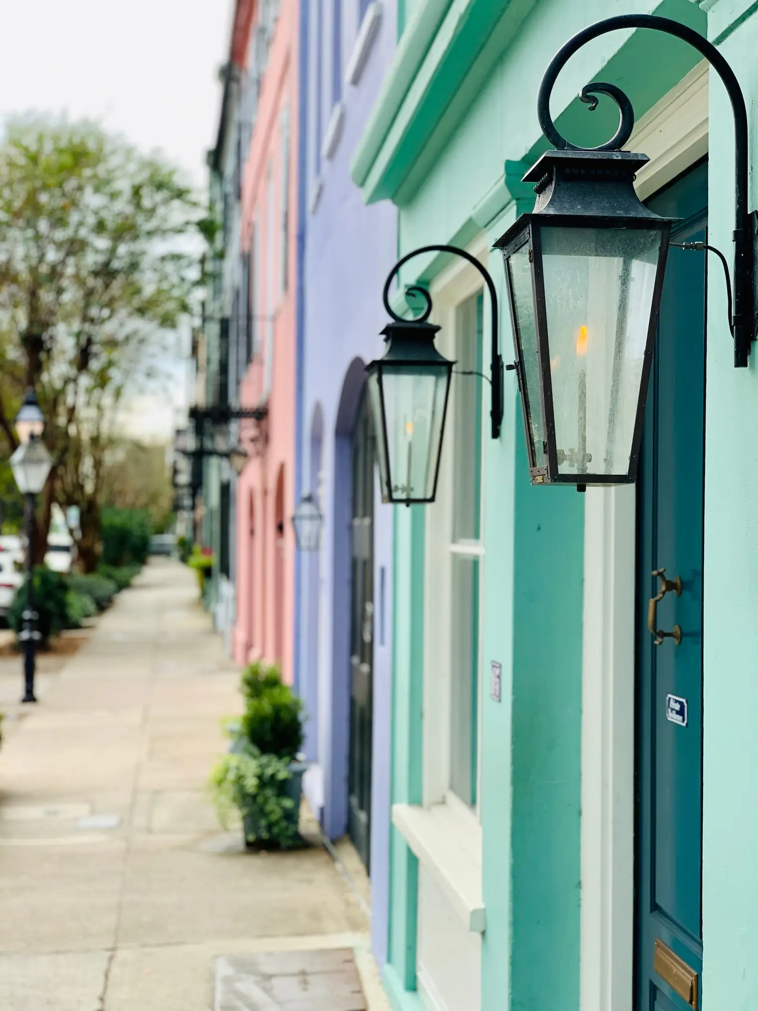 Gas lanterns along Rainbow Row's pastel historic houses in Charleston